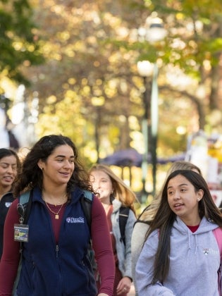 a group of students walking down a sidewalk
